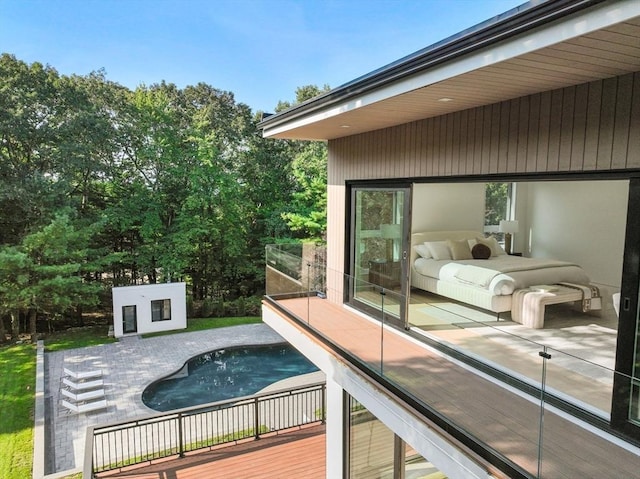 view of swimming pool with a wooden deck and an outdoor structure