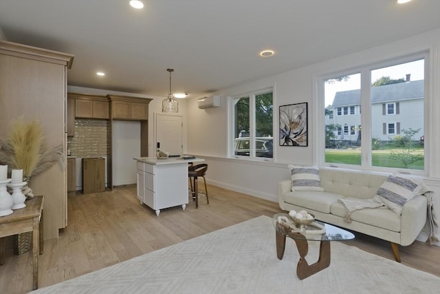 living room with an AC wall unit and light hardwood / wood-style floors