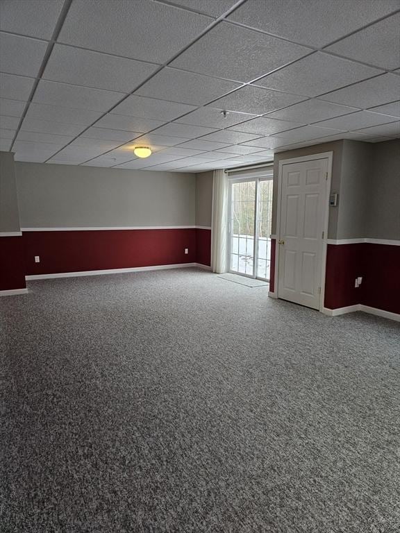 spare room featuring carpet floors and a drop ceiling