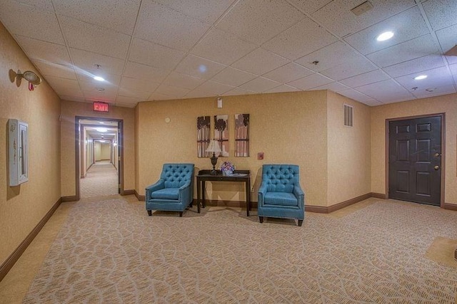 sitting room featuring a paneled ceiling and light carpet