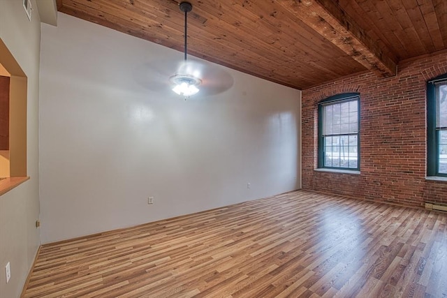 unfurnished dining area with wood ceiling, ceiling fan, beam ceiling, light hardwood / wood-style floors, and brick wall