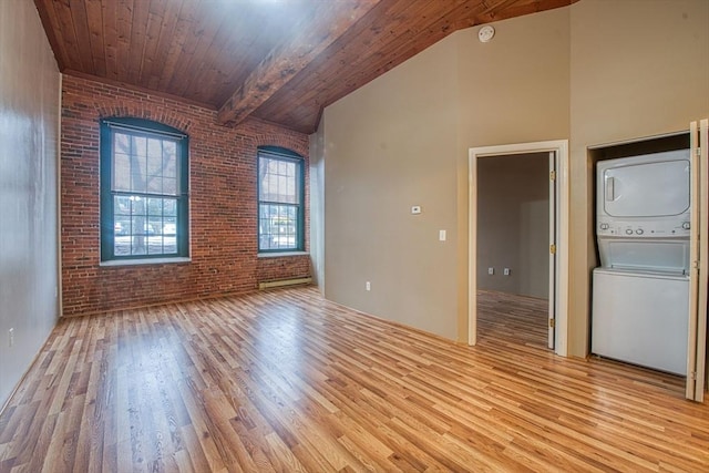 unfurnished room with brick wall, stacked washer / drying machine, wood ceiling, and light hardwood / wood-style flooring