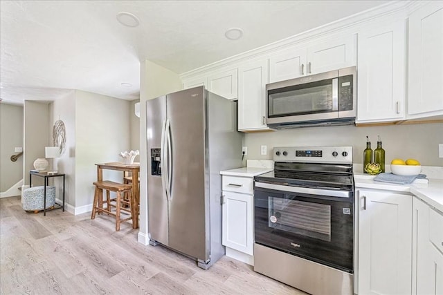 1009 Point Rd, Marion, MA 02738 - kitchen with stainless steel appliances, light countertops, light wood finished floors, and white cabinets