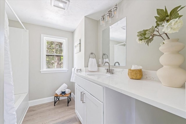 1009 Point Rd, Marion, MA 02738 - bathroom with vanity, wood finished floors, baseboards, and shower / tub combo