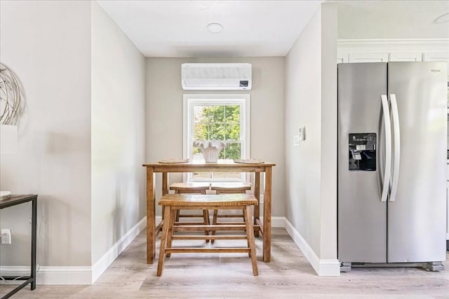 1009 Point Rd, Marion, MA 02738 - dining room featuring a wall unit AC, light wood-style floors, and baseboards