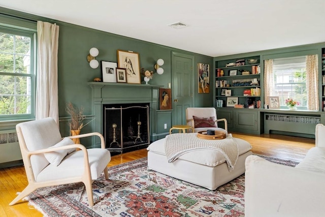 sitting room with a healthy amount of sunlight, radiator heating unit, and visible vents