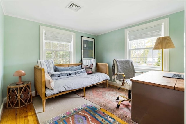 bedroom featuring multiple windows, visible vents, wood finished floors, and baseboards