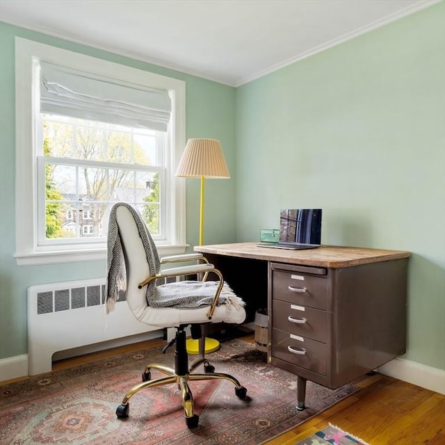 office space with crown molding, wood finished floors, and baseboards