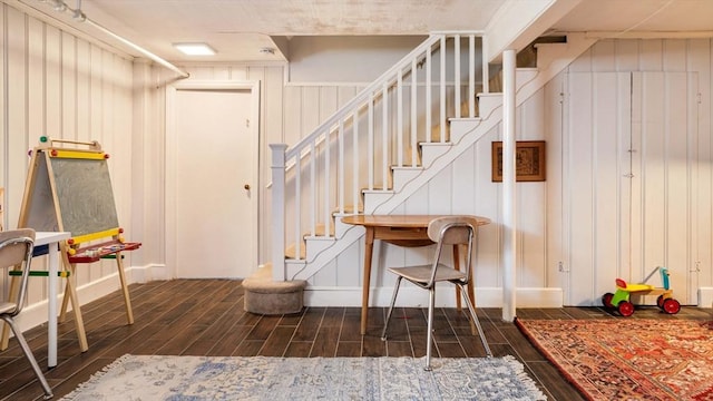 stairs with baseboards, a decorative wall, and wood finish floors