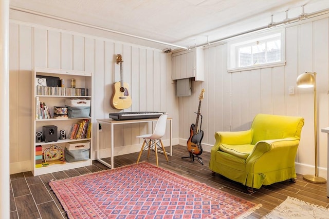 living area featuring baseboards and wood tiled floor