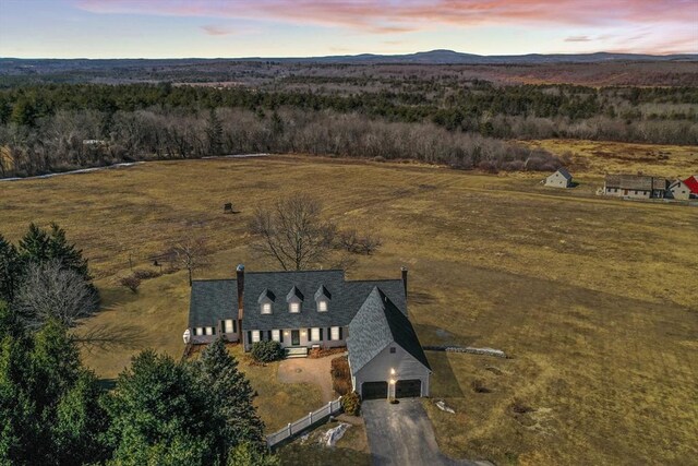 aerial view at dusk featuring a rural view and a mountain view