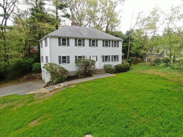 83 Cider Mill Rd, Sudbury, MA 01776 - colonial-style house featuring driveway, a chimney, a garage, a front yard, and a shingled roof