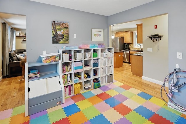 21 Rose Ln, Uxbridge, MA 01569 - recreation room featuring light wood finished floors, a sink, and baseboards