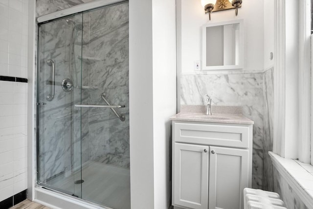 369 Tappan St Unit 8, Brookline, MA 02445 - bathroom with radiator heating unit, a marble finish shower, vanity, and tile walls