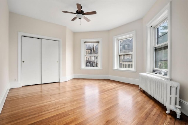 369 Tappan St Unit 8, Brookline, MA 02445 - unfurnished bedroom featuring radiator, light wood-type flooring, a closet, and ceiling fan