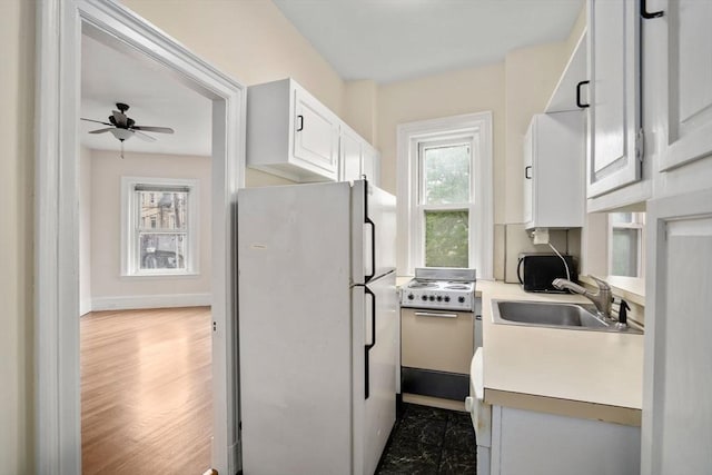 369 Tappan St Unit 8, Brookline, MA 02445 - kitchen featuring freestanding refrigerator, range, a ceiling fan, light countertops, and white cabinetry