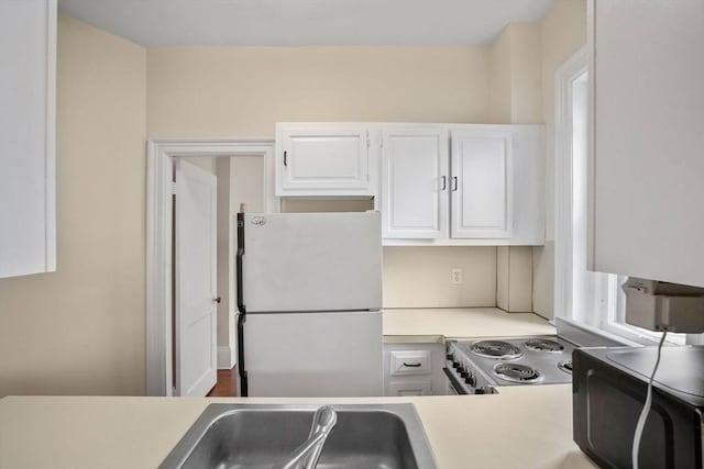 369 Tappan St Unit 8, Brookline, MA 02445 - kitchen featuring freestanding refrigerator, light countertops, white cabinetry, and stainless steel electric range oven