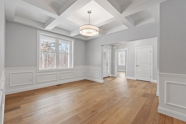 interior space with beam ceiling, coffered ceiling, and light hardwood / wood-style flooring