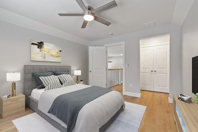 bedroom featuring ceiling fan, light hardwood / wood-style flooring, a closet, and vaulted ceiling