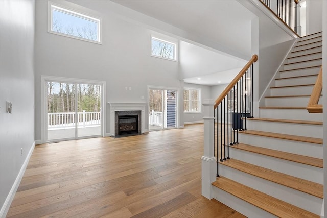 unfurnished living room with a high ceiling and light hardwood / wood-style floors