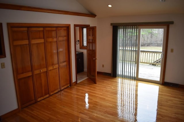 interior space with light hardwood / wood-style floors and lofted ceiling