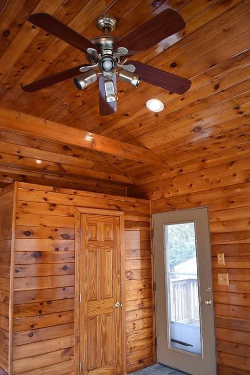 entryway featuring beam ceiling, wooden walls, and wooden ceiling