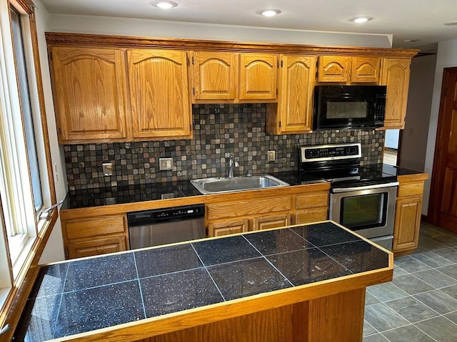 kitchen with sink, light tile patterned floors, appliances with stainless steel finishes, tasteful backsplash, and kitchen peninsula