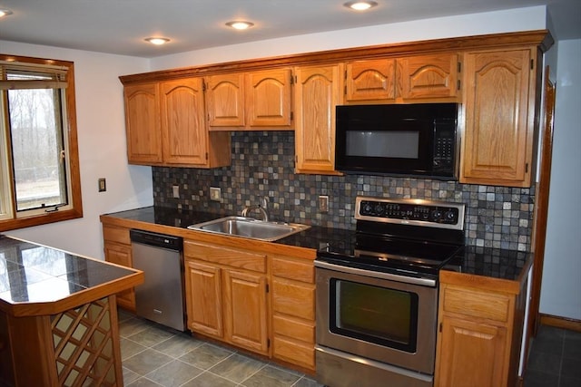 kitchen with backsplash, sink, dark tile patterned floors, and appliances with stainless steel finishes