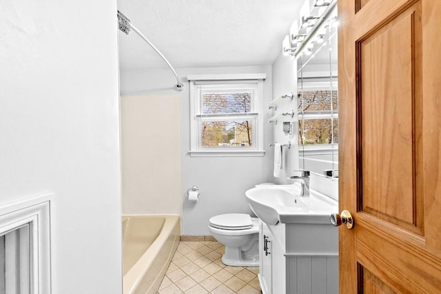 bathroom featuring tile patterned flooring, vanity, toilet, baseboards, and a textured ceiling