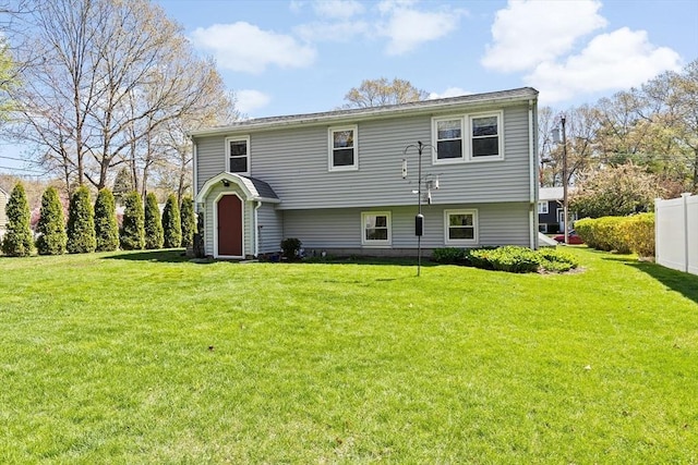 view of front of house featuring fence and a front yard