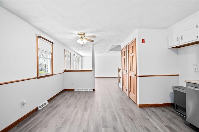 interior space featuring visible vents, a ceiling fan, light wood-style floors, and dishwasher