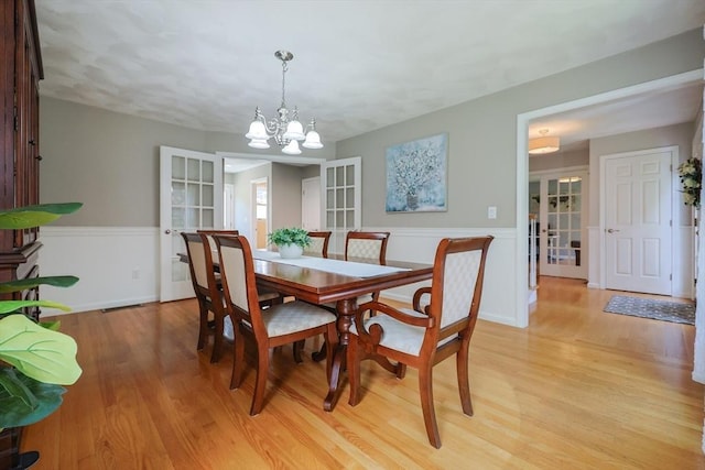 70 Huntsbridge Rd, North Attleboro, MA 02760 - dining space with french doors, light wood-style flooring, a wainscoted wall, and a chandelier