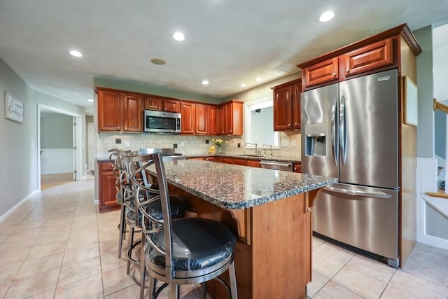 70 Huntsbridge Rd, North Attleboro, MA 02760 - kitchen with appliances with stainless steel finishes, backsplash, a kitchen bar, light tile patterned flooring, and recessed lighting