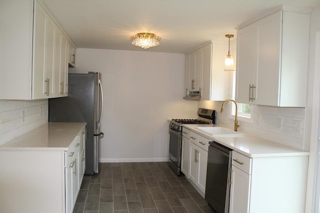 kitchen with a sink, appliances with stainless steel finishes, white cabinets, and backsplash