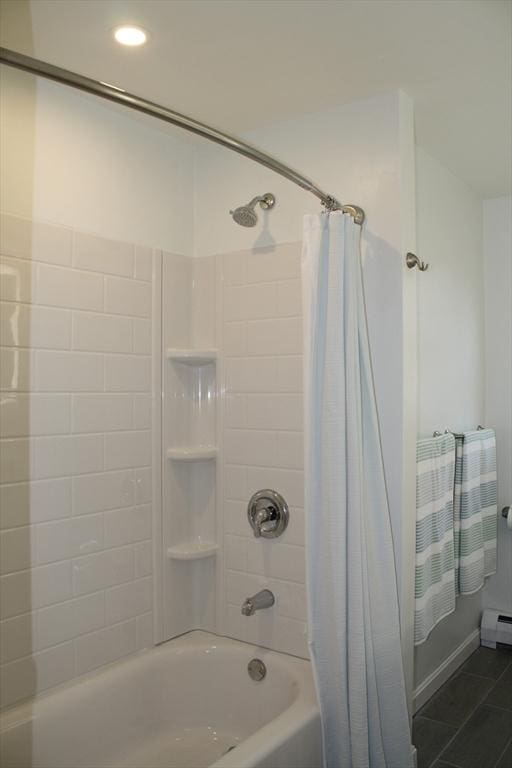 bathroom featuring shower / bath combo with shower curtain, a baseboard heating unit, and tile patterned flooring