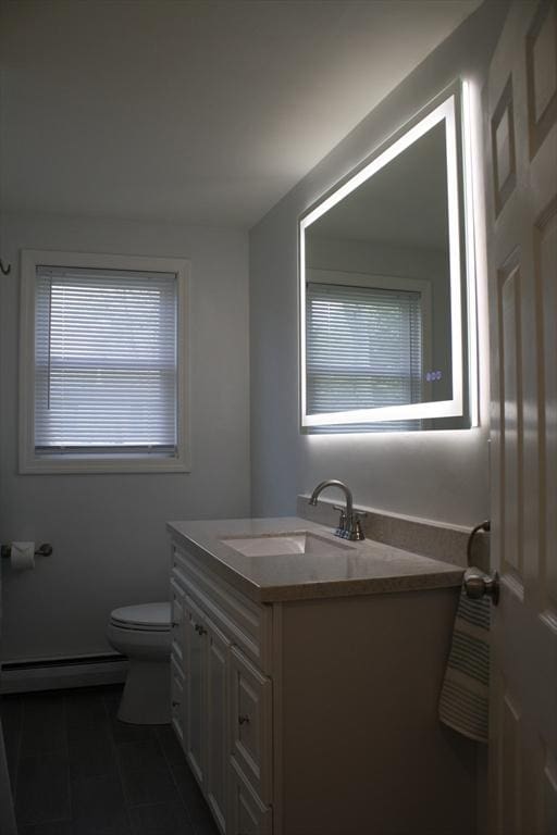 bathroom featuring toilet, baseboard heating, tile patterned flooring, and vanity