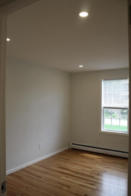 spare room featuring recessed lighting, baseboards, wood finished floors, and baseboard heating