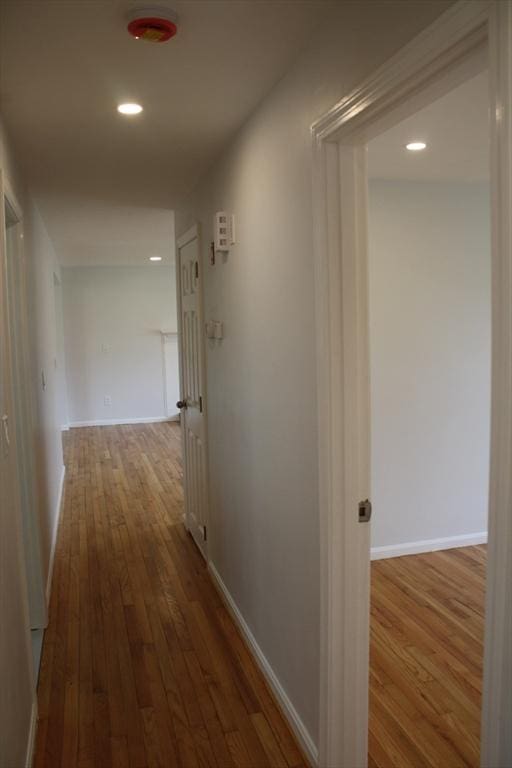 hallway featuring recessed lighting, baseboards, and hardwood / wood-style floors