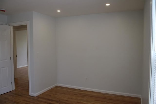empty room featuring recessed lighting, baseboards, and wood finished floors
