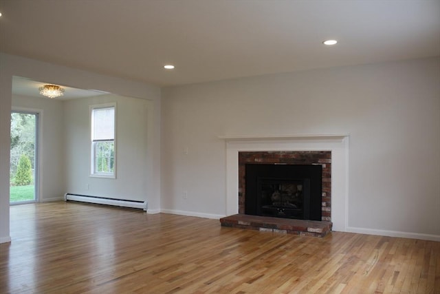 unfurnished living room featuring baseboards, a baseboard radiator, wood finished floors, and recessed lighting