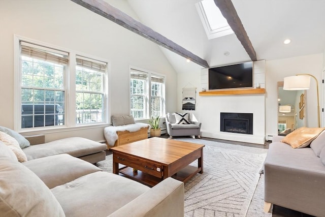 living area with a skylight, high vaulted ceiling, beamed ceiling, a glass covered fireplace, and recessed lighting