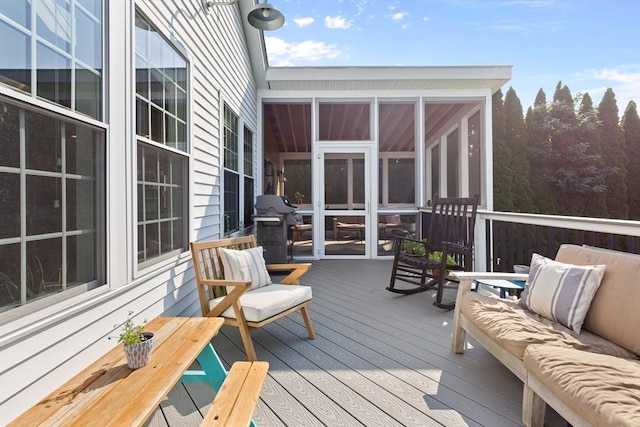 wooden deck featuring a sunroom and area for grilling