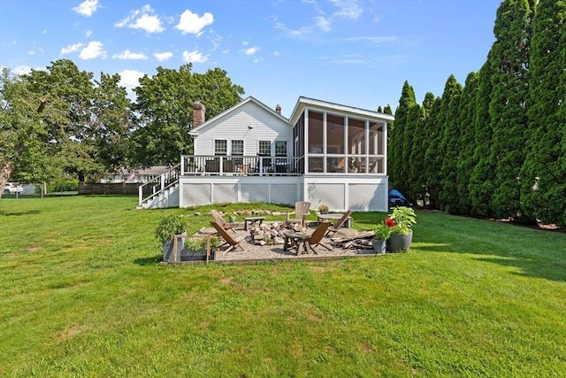 back of house featuring a wooden deck, a patio area, a sunroom, an outdoor fire pit, and a yard