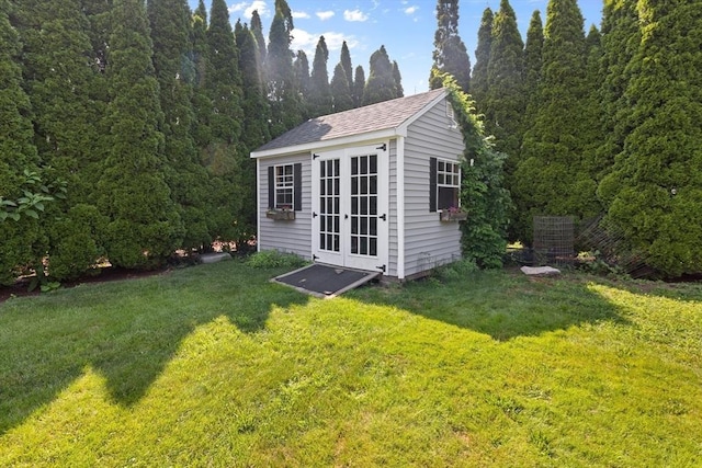 view of outbuilding featuring an outdoor structure, french doors, and a forest view