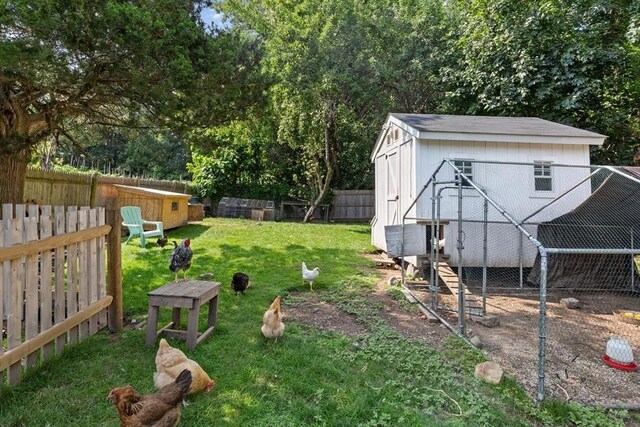 view of yard with an outdoor structure, a fenced backyard, exterior structure, and a storage shed