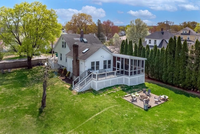 back of property with a yard, a patio, a sunroom, and stairway