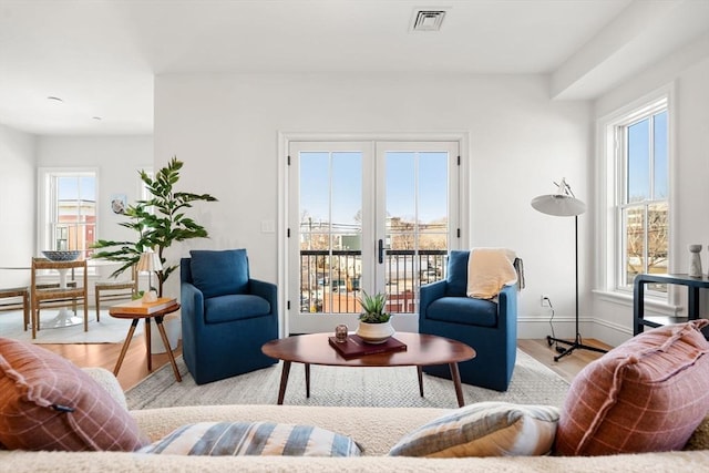 living room featuring baseboards, visible vents, and light wood-style floors
