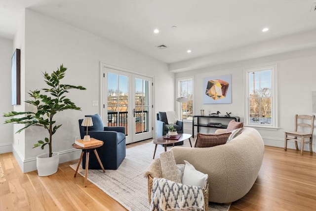 living room with baseboards, visible vents, light wood-style flooring, and recessed lighting