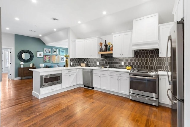 34 Alpha Rd Unit 3, Boston, MA 02124 - kitchen featuring appliances with stainless steel finishes, vaulted ceiling, white cabinets, light countertops, and backsplash