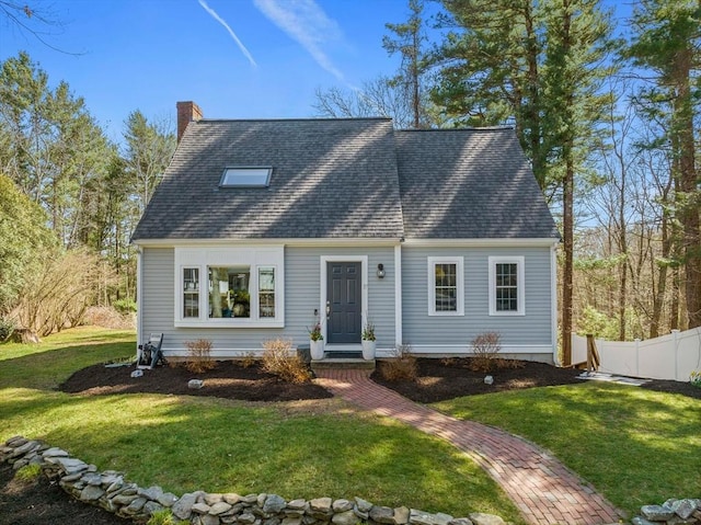 cape cod home featuring roof with shingles, a chimney, a front lawn, and fence
